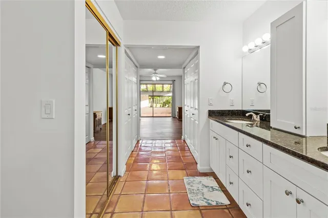 a large hall with stainless steel appliances granite countertop a sink and wooden floor