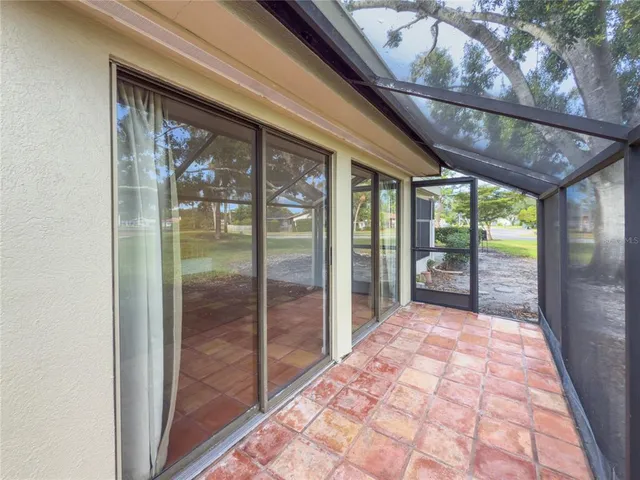 a bathroom with a glass door shower and view of a hallway