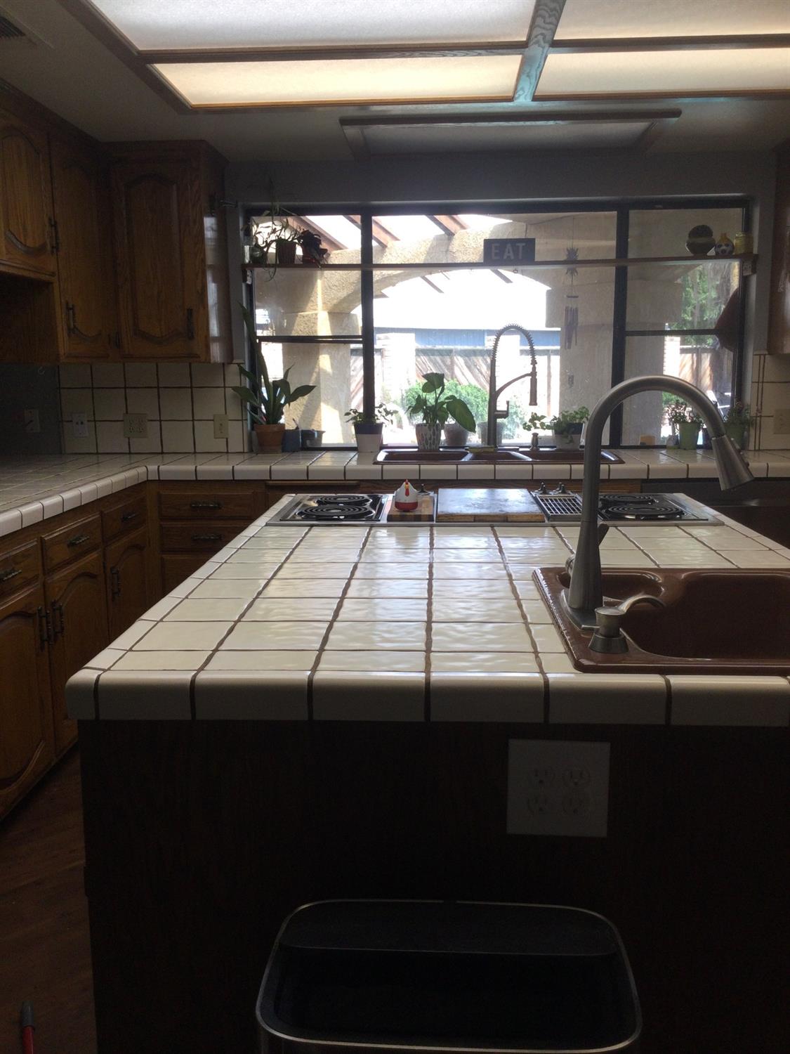 308 Monroe Street Coalinga, CA 93210 - Photo 9 of 35 a view of a kitchen with a sink and wooden cabinets