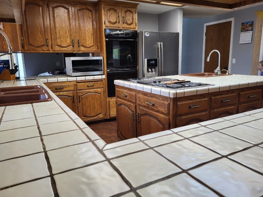 308 Monroe Street Coalinga, CA 93210 - Photo 10 of 35 a kitchen with stainless steel appliances granite countertop a stove a sink and a microwave