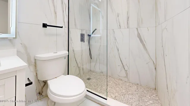 a white toilet sitting next to a bath tub