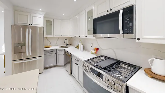 a kitchen with stainless steel appliances granite countertop a stove a refrigerator and a microwave