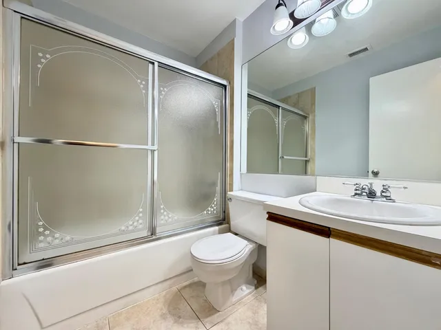 an empty room with a window and a ceiling fan