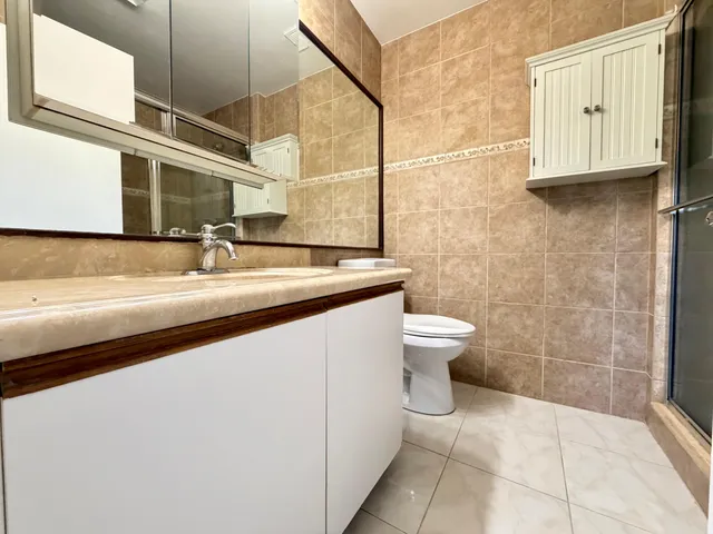 an empty room with wooden floor and windows with curtains