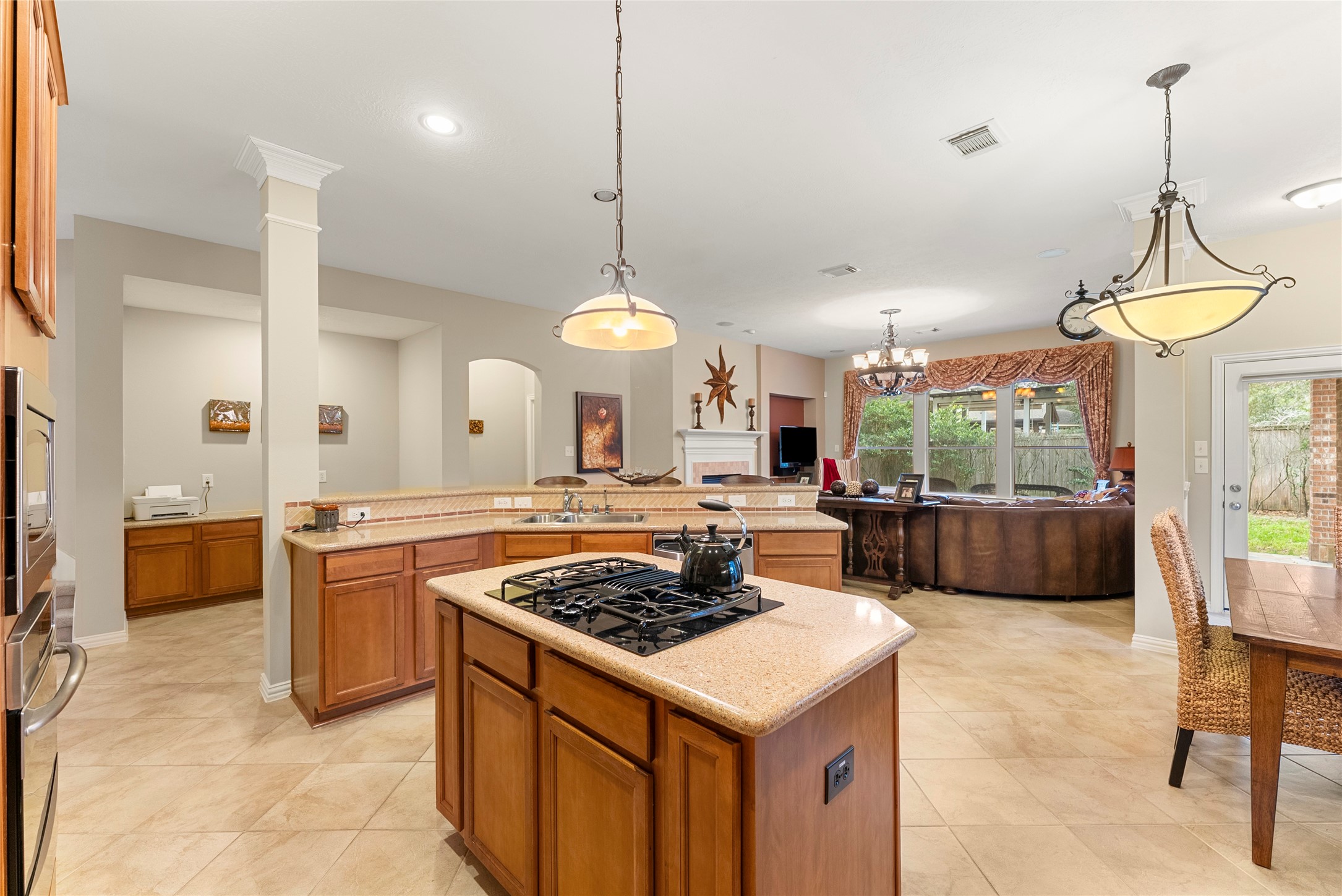 55 Granite Path Place Spring, TX 77389 - Photo 16 of 50 a kitchen with a stove a sink a counter top space and living room view