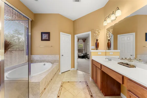a spacious bathroom with a tub sink shower and mirror