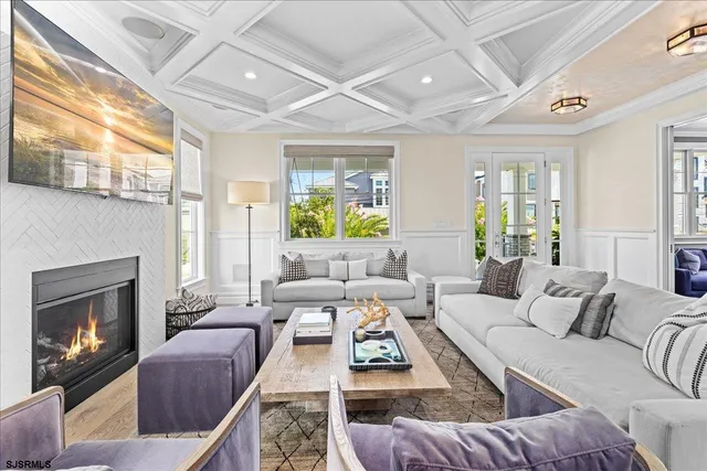 a kitchen with stainless steel appliances a stove a sink dishwasher a refrigerator and white cabinets with wooden floor