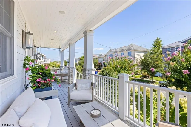 a living room with furniture a chandelier and a flat screen tv