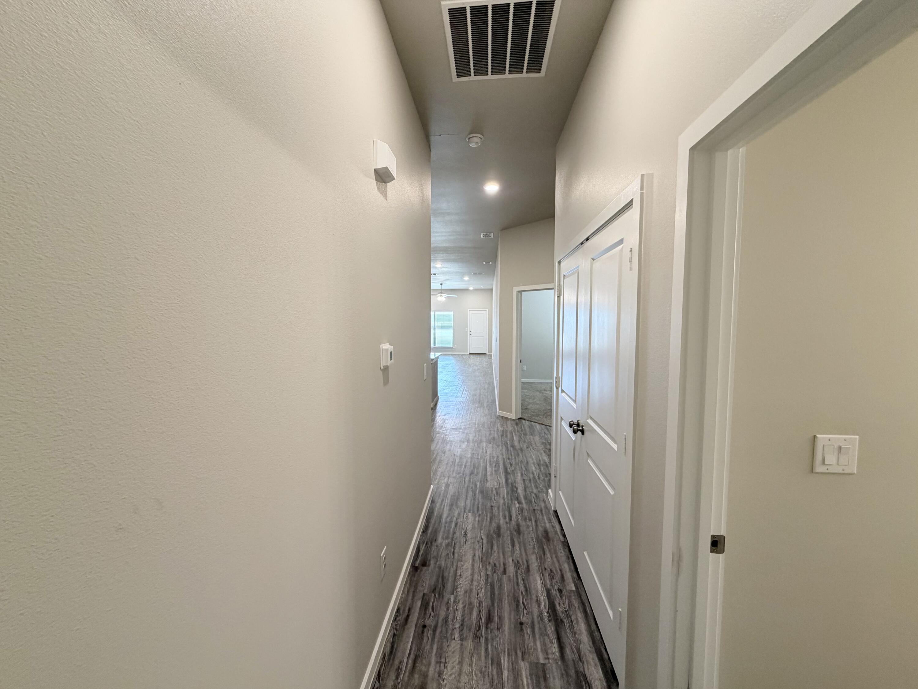 1619 133rd Street, Unit B Lubbock, TX 79423 - Photo 11 of 24 a view of a hallway with wooden floor and staircase
