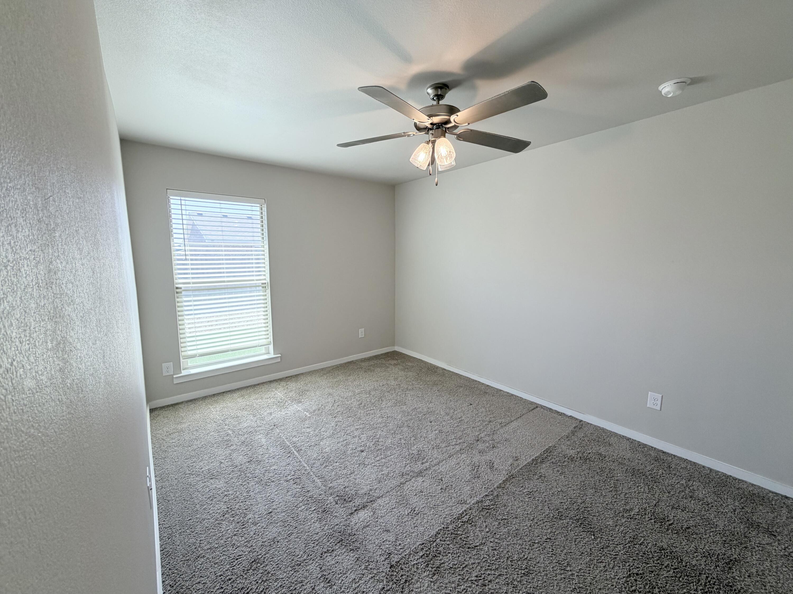 1619 133rd Street, Unit B Lubbock, TX 79423 - Photo 13 of 24 an empty room with a window and a fan