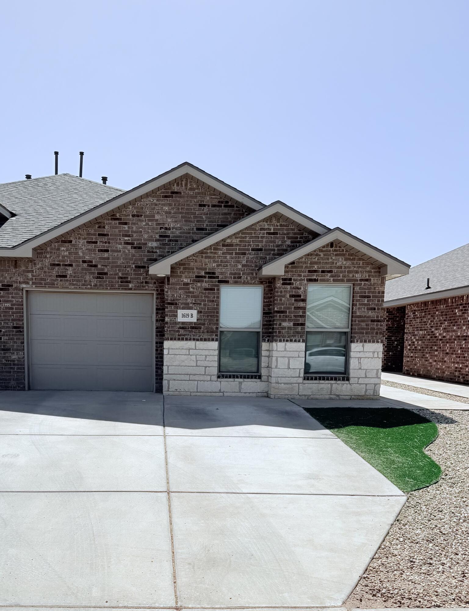 1619 133rd Street, Unit B Lubbock, TX 79423 - Photo 2 of 24 a front view of a house with a yard