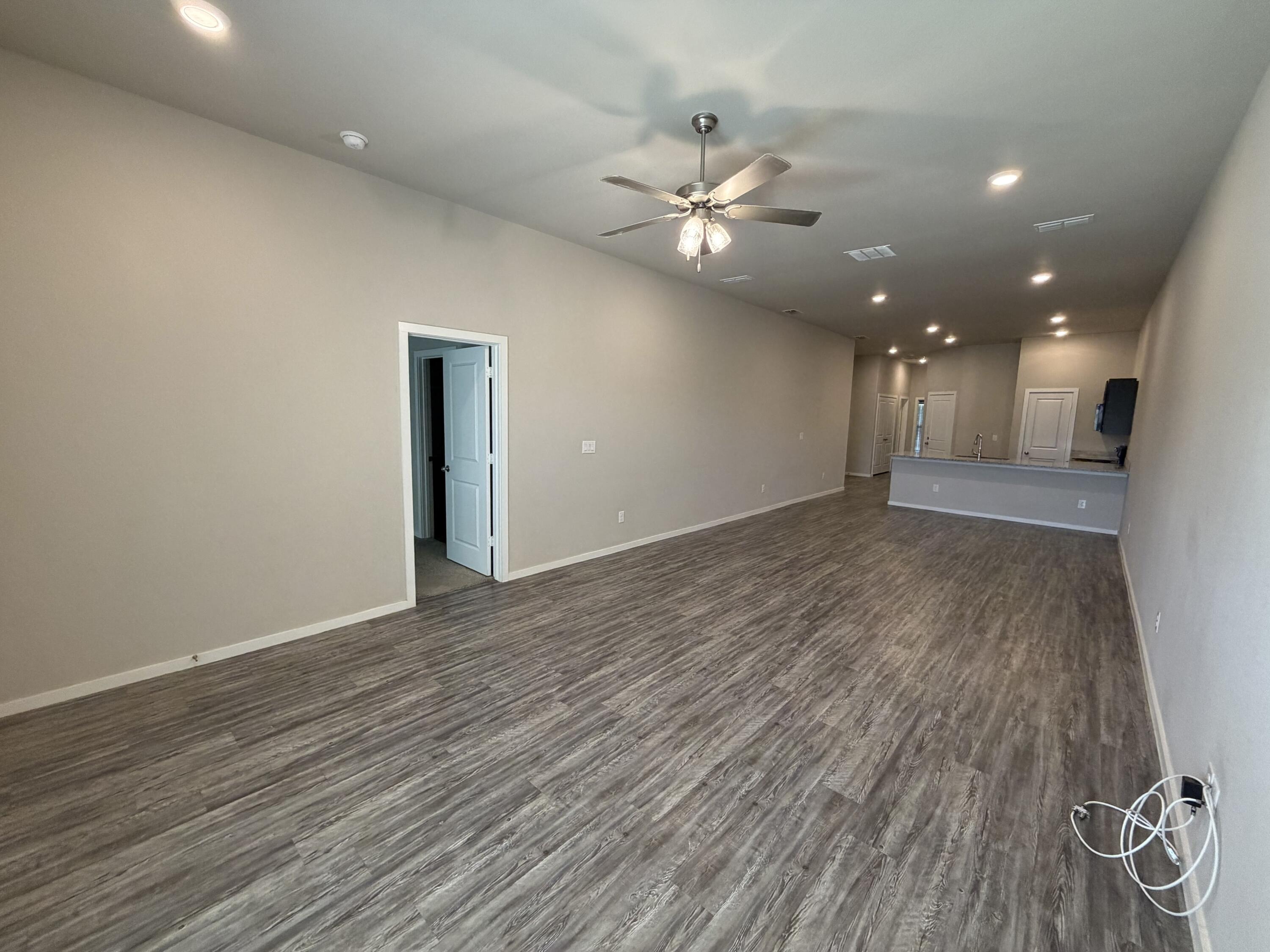 1619 133rd Street, Unit B Lubbock, TX 79423 - Photo 21 of 24 a view of an empty room with wooden floor and fan