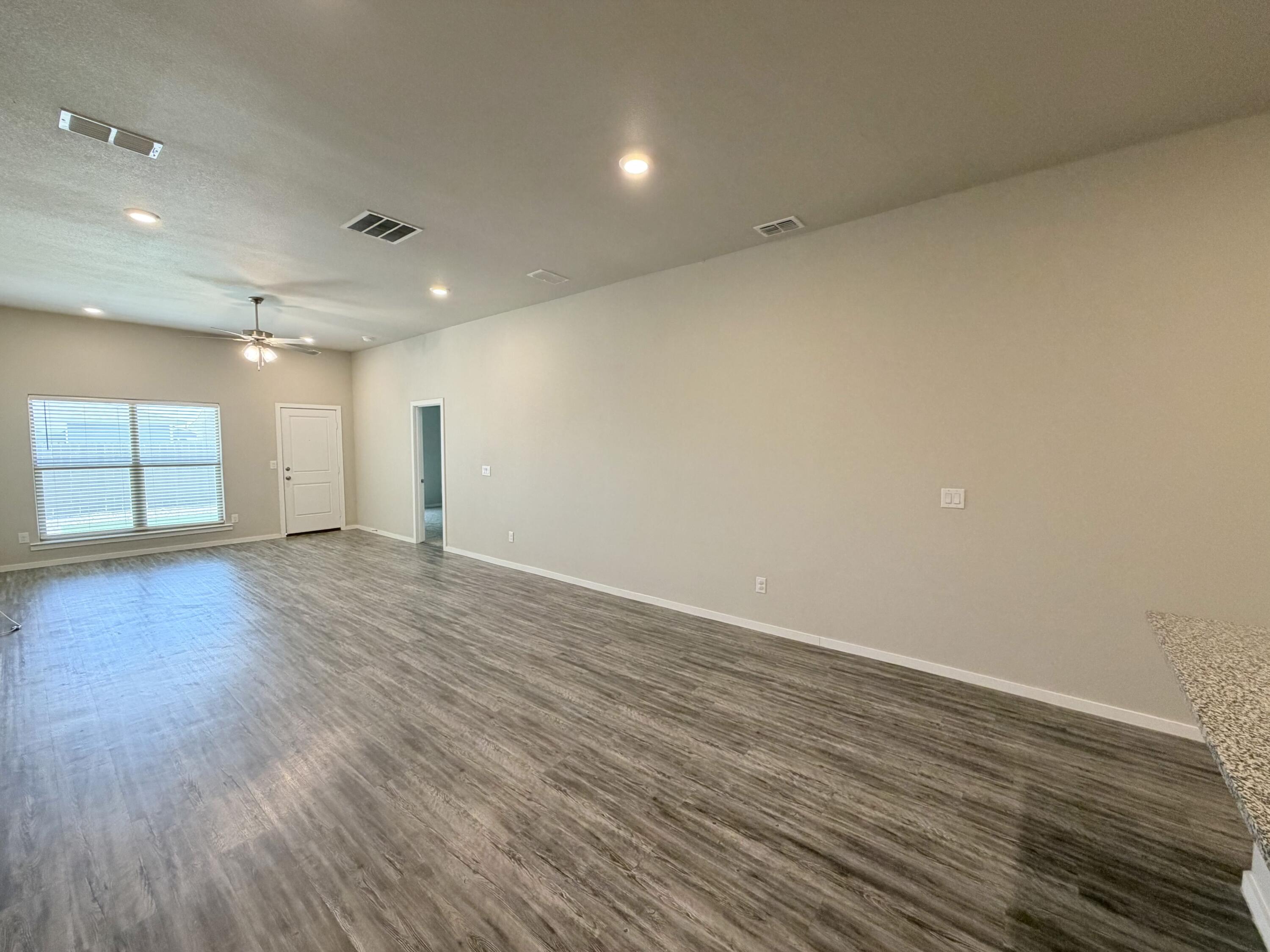 1619 133rd Street, Unit B Lubbock, TX 79423 - Photo 22 of 24 a view of an empty room with wooden floor