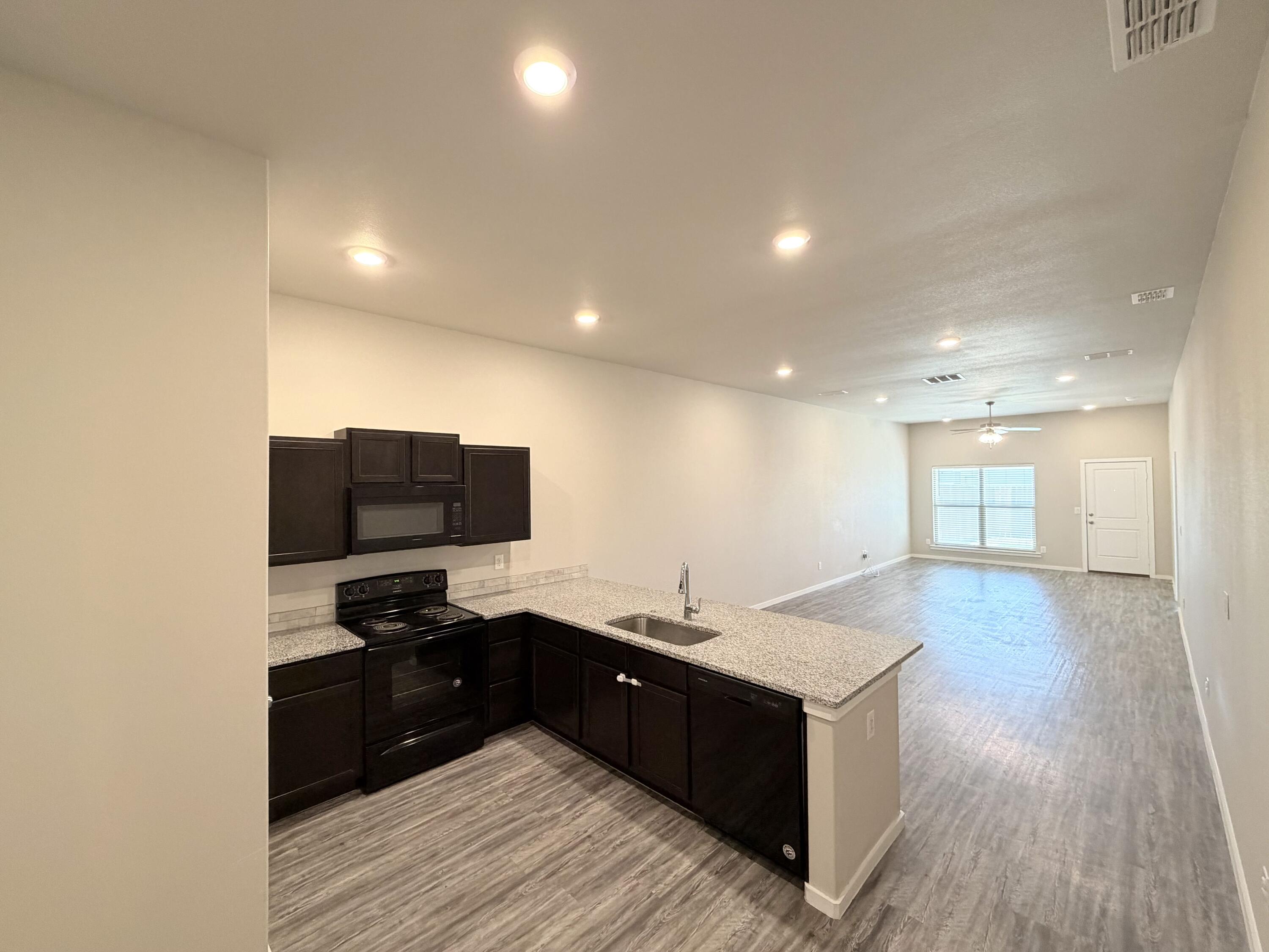 1619 133rd Street, Unit B Lubbock, TX 79423 - Photo 6 of 24 a kitchen with stainless steel appliances granite countertop a sink and a stove