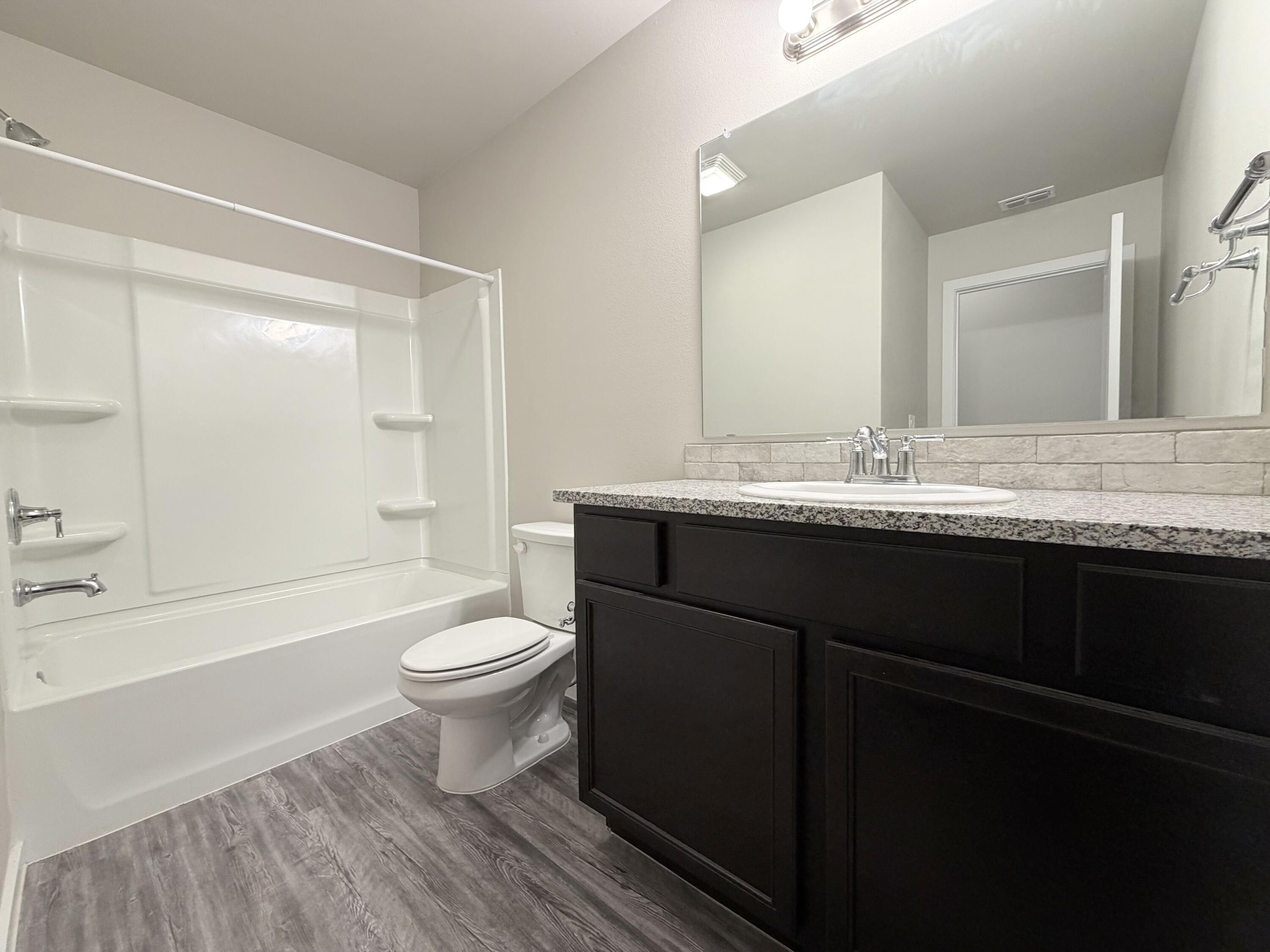 1619 133rd Street, Unit B Lubbock, TX 79423 - Photo 8 of 24 a bathroom with a sink a toilet and shower
