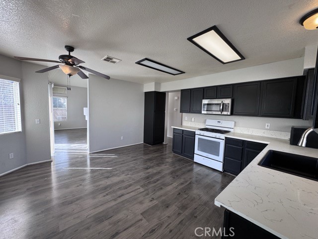 43370 Corte Benitez Temecula, CA 92592 - Photo 19 of 46 a kitchen with stainless steel appliances kitchen island a cabinets and wooden floor