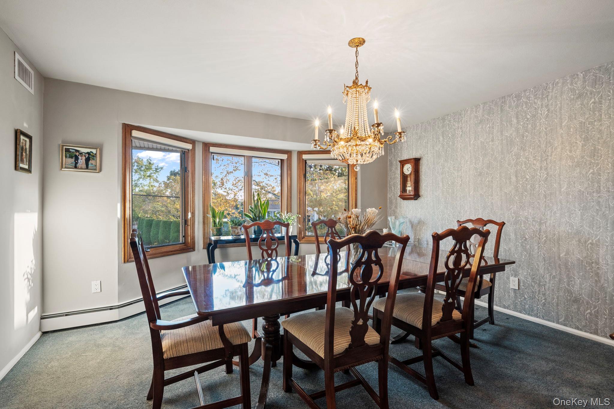 158 Old Courthouse Road Manhasset Hills, NY 11040 - Photo 12 of 47 a view of a dining room with furniture a chandelier and wooden floor