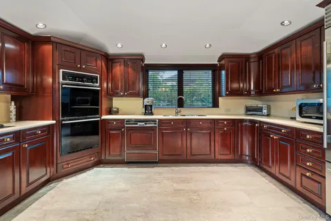 a kitchen with a sink wooden cabinets and stainless steel appliances