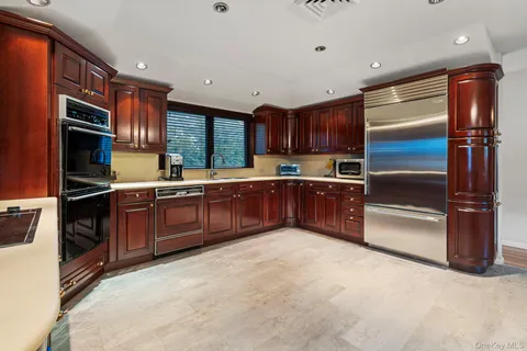 a kitchen with stainless steel appliances granite countertop a refrigerator and a sink