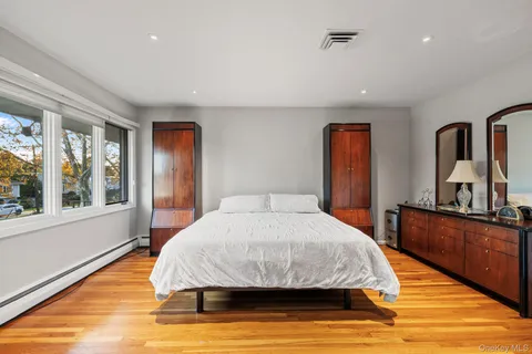 a bedroom with a large bed and wooden floor