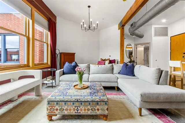 a living room with furniture chandelier and a large window