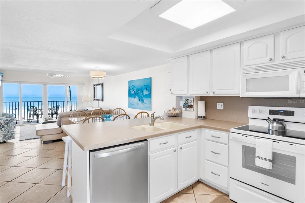 60 Gulf Boulevard, Unit 203 Indian Rocks Beach, FL 33785 - Photo 12 of 53 a kitchen with kitchen island granite countertop a sink a stove cabinets and counter space