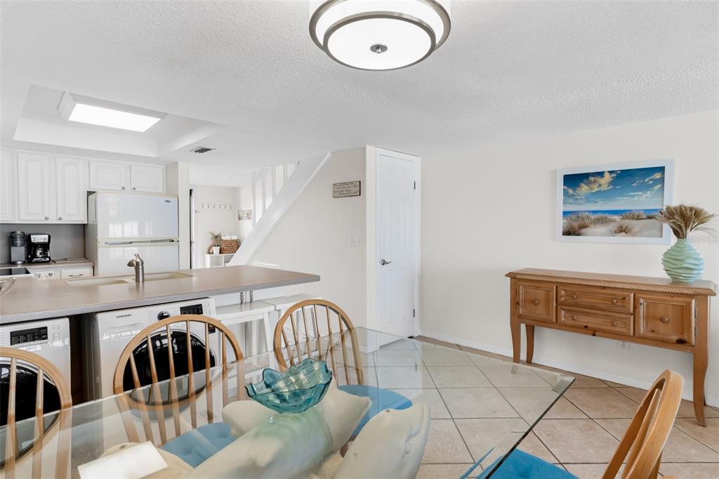 60 Gulf Boulevard, Unit 203 Indian Rocks Beach, FL 33785 - Photo 18 of 53 a kitchen with stainless steel appliances granite countertop a sink a stove a refrigerator a microwave oven with white cabinets and wooden floor
