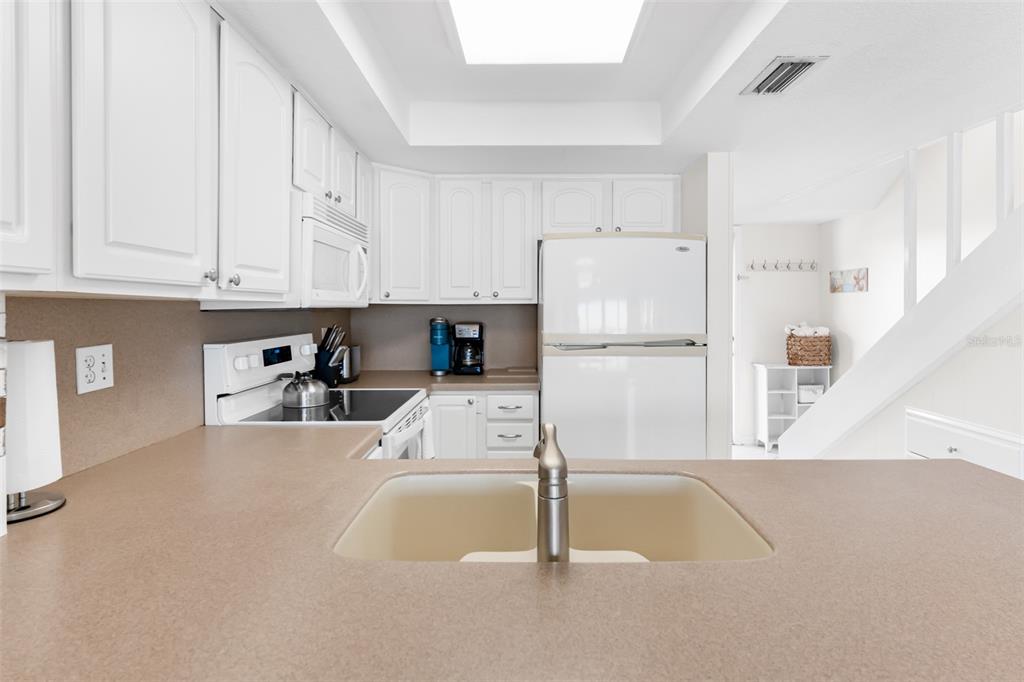 60 Gulf Boulevard, Unit 203 Indian Rocks Beach, FL 33785 - Photo 20 of 53 a kitchen with a refrigerator a white cabinets and white appliances