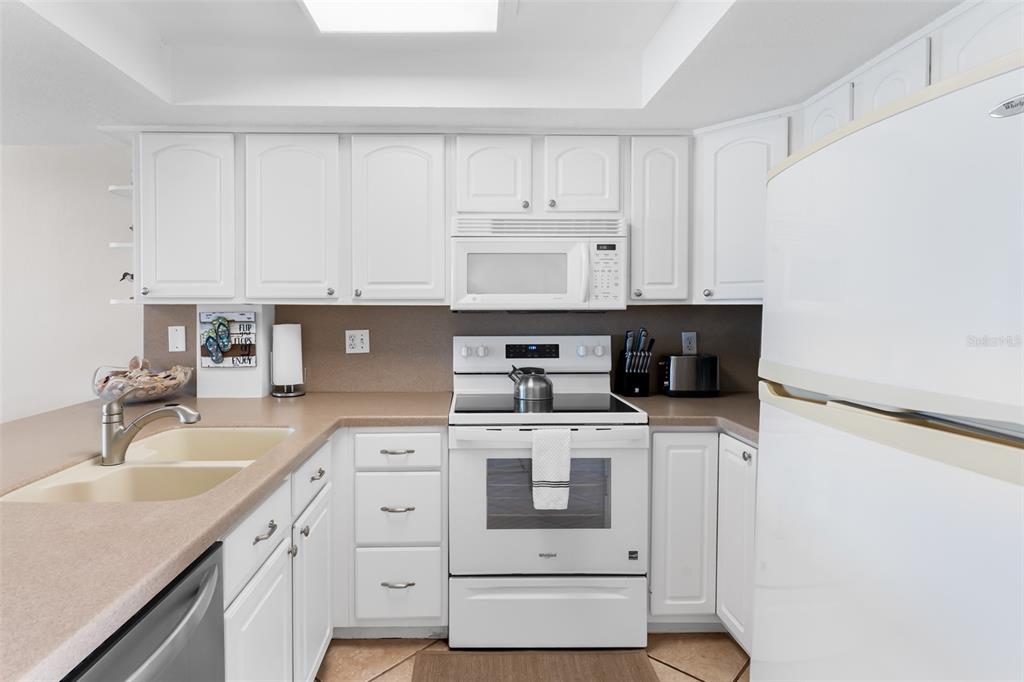 60 Gulf Boulevard, Unit 203 Indian Rocks Beach, FL 33785 - Photo 22 of 53 a kitchen with stainless steel appliances granite countertop a sink stove and cabinets