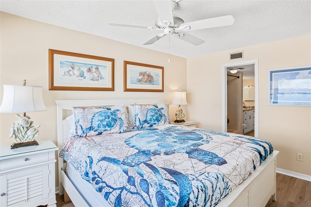 60 Gulf Boulevard, Unit 203 Indian Rocks Beach, FL 33785 - Photo 25 of 53 a bedroom with bed and wall painting