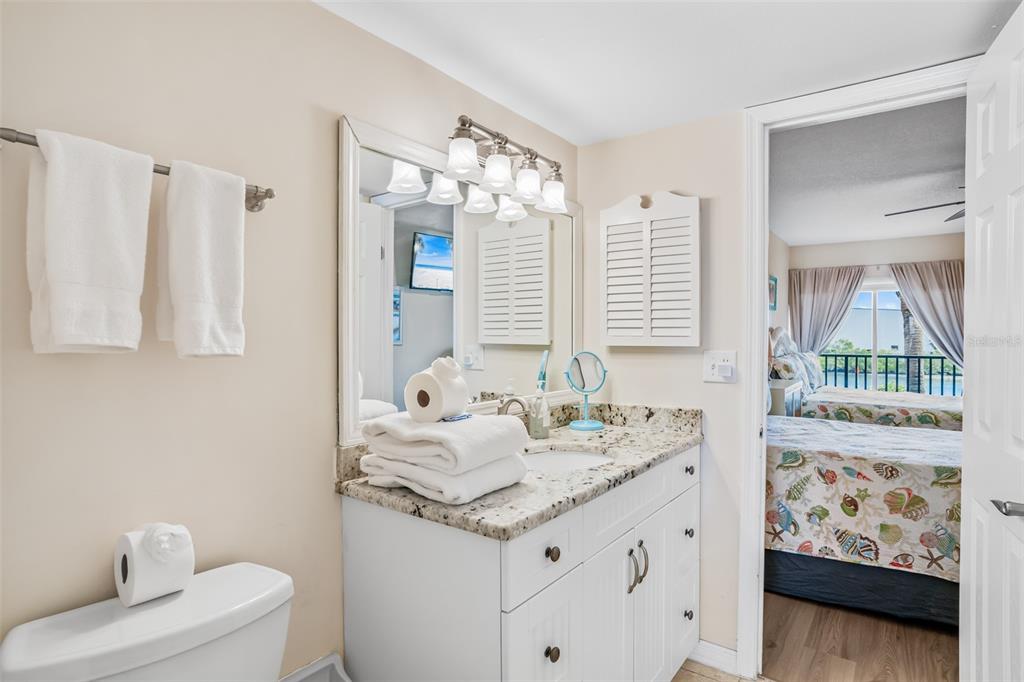 60 Gulf Boulevard, Unit 203 Indian Rocks Beach, FL 33785 - Photo 33 of 53 a bathroom with a granite countertop sink and a mirror