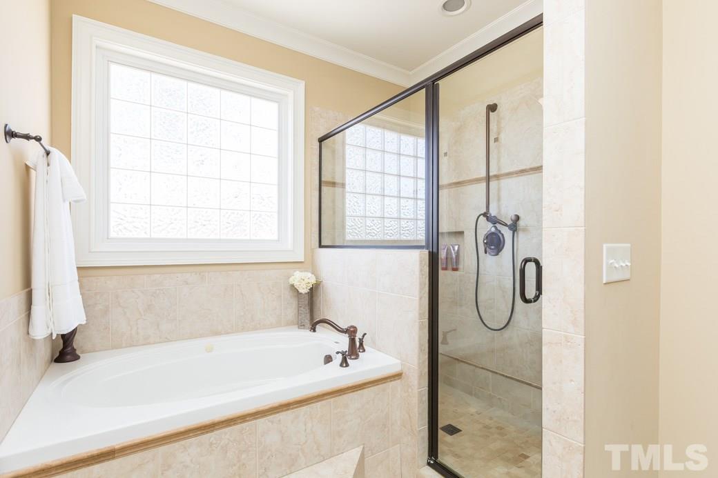 5342 Landguard Drive Raleigh, NC 27613 - Photo 16 of 25 a bathroom with a bath tub and a shower