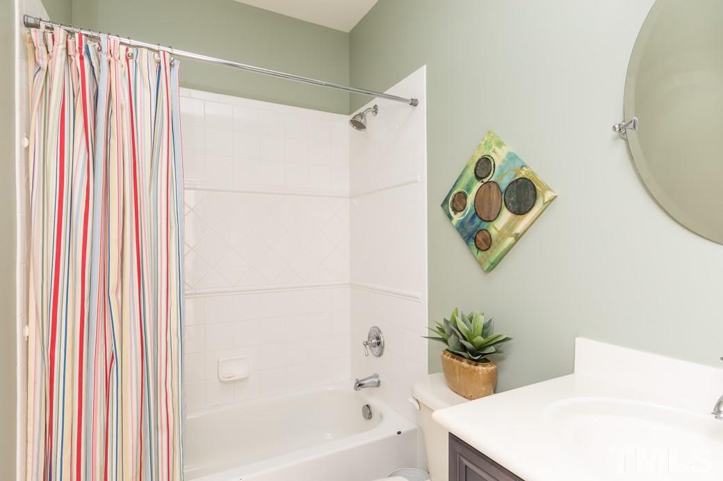 5342 Landguard Drive Raleigh, NC 27613 - Photo 21 of 25 a bathroom with a shower curtain and a bathtub