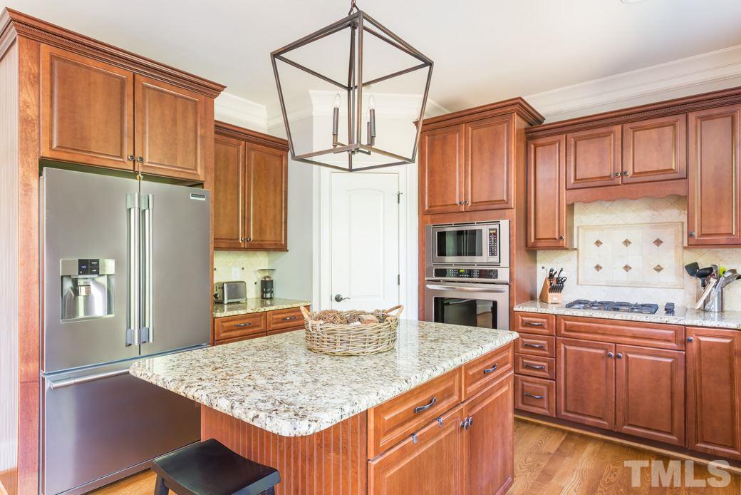 5342 Landguard Drive Raleigh, NC 27613 - Photo 8 of 25 a kitchen with stainless steel appliances granite countertop a sink refrigerator and cabinets