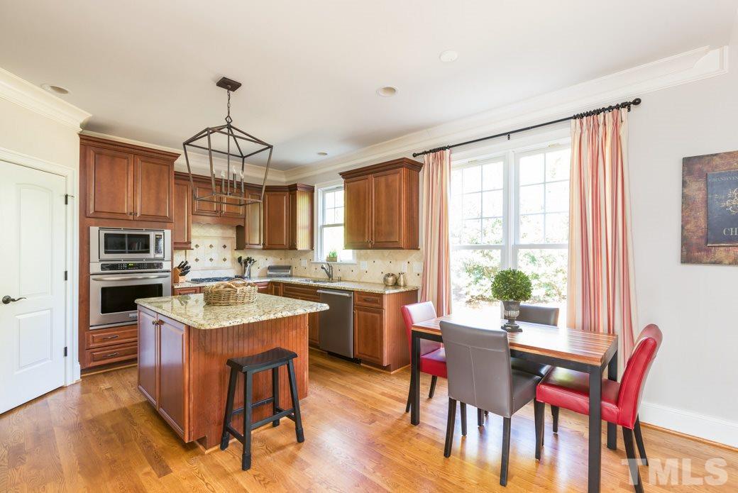 5342 Landguard Drive Raleigh, NC 27613 - Photo 10 of 25 a kitchen with a dining table chairs stainless steel appliances and cabinets