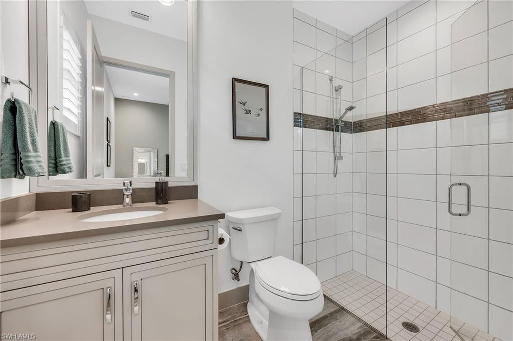 6184 Antigua Way Naples, FL 34113 - Photo 12 of 49 a bathroom with a granite countertop sink a toilet and shower