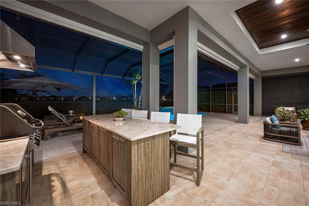 6184 Antigua Way Naples, FL 34113 - Photo 24 of 49 a patio with a table and chairs and potted plants