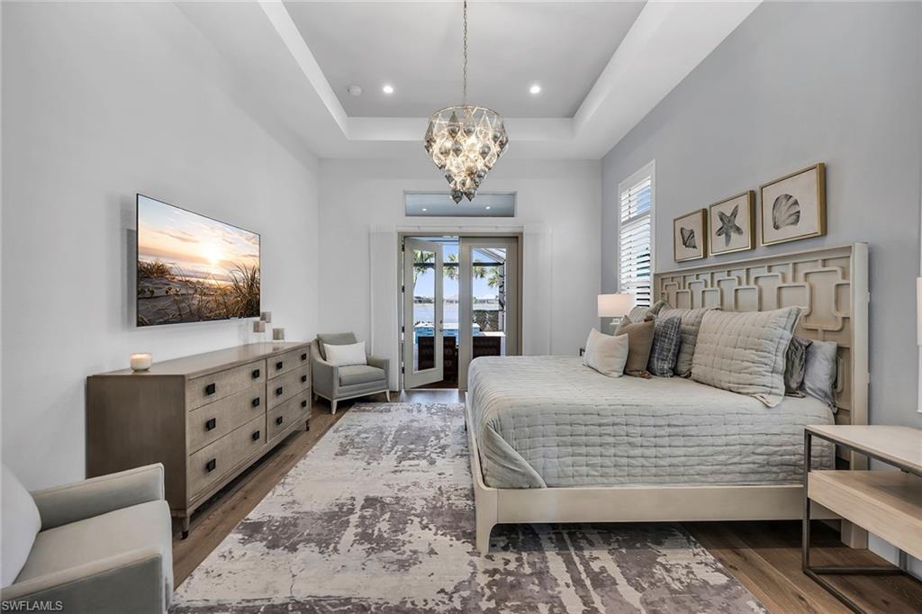 6184 Antigua Way Naples, FL 34113 - Photo 7 of 49 a bedroom with a bed and a flat screen tv