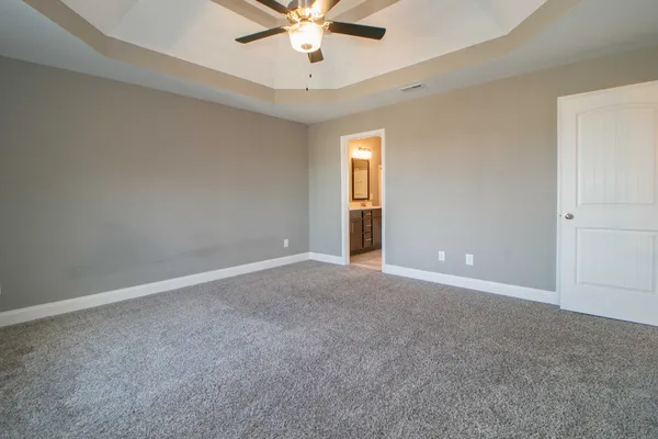 an empty room with a window and a ceiling fan