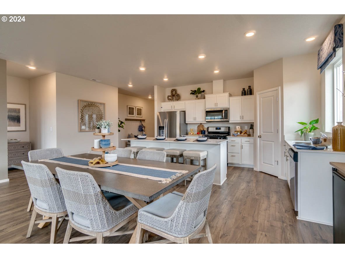 2961 V Street Springfield, OR 97477 - Photo 13 of 24 a kitchen with stainless steel appliances kitchen island granite countertop a dining table chairs and stove