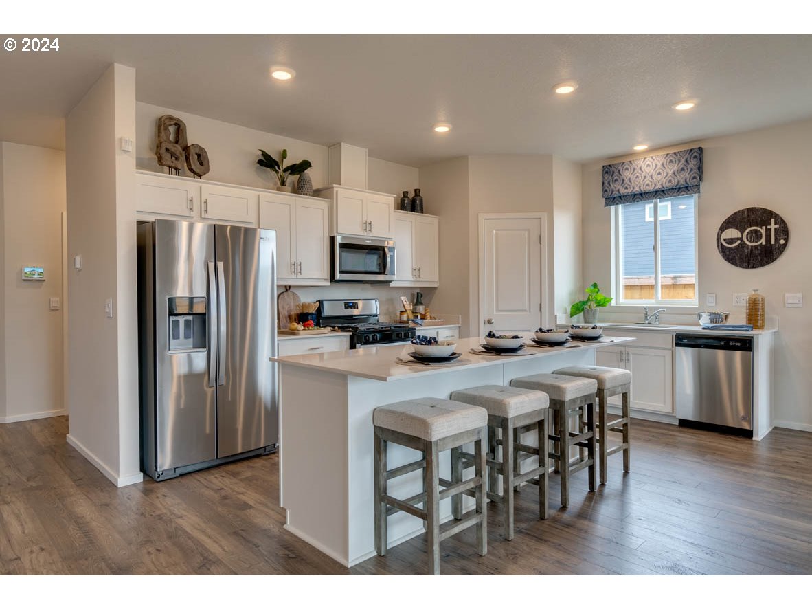 2961 V Street Springfield, OR 97477 - Photo 10 of 24 a kitchen with stainless steel appliances a table chairs refrigerator and microwave