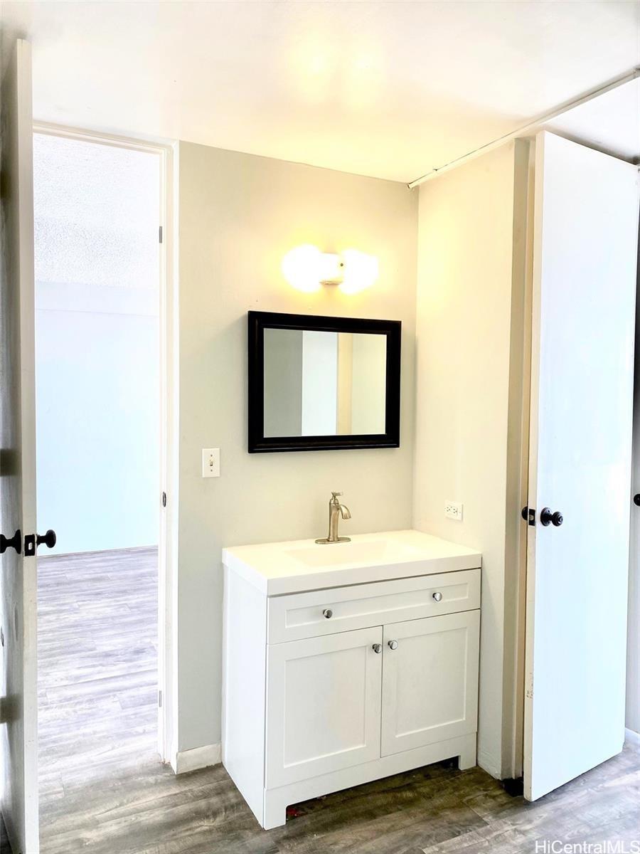 99-70 Kauhale Street, Unit 606 Aiea, HI 96701 - Photo 7 of 8 a bathroom with a toilet sink and mirror