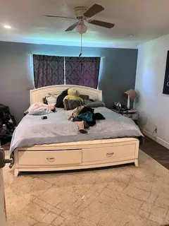 a bed sitting in a room next to a lamp