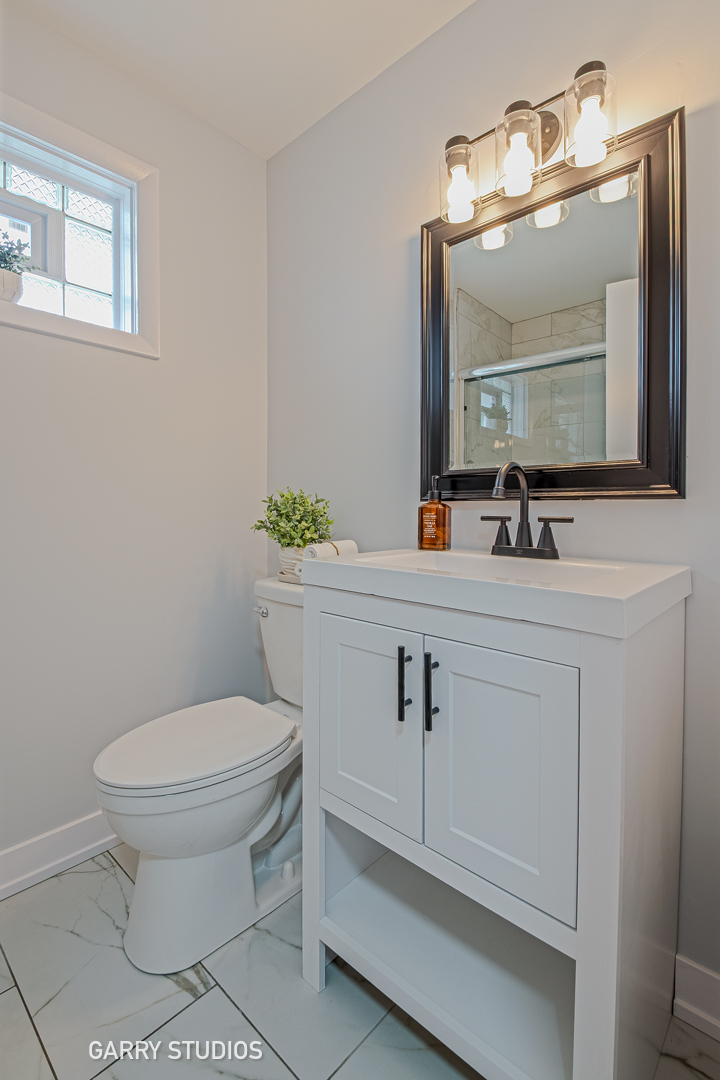 1212 North Wheeling Road Mount Prospect, IL 60056 - Photo 13 of 19 a bathroom with a toilet sink and mirror