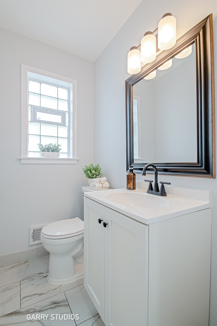 1212 North Wheeling Road Mount Prospect, IL 60056 - Photo 8 of 19 a bathroom with a sink a toilet and mirror