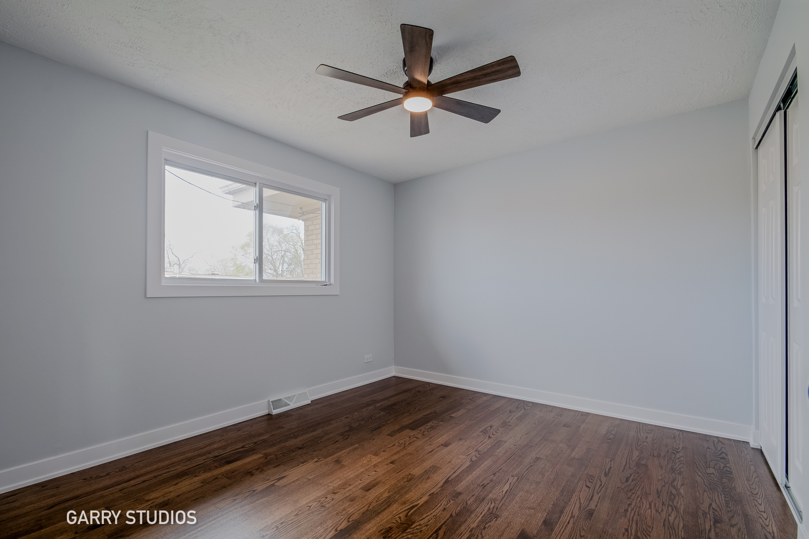 1212 North Wheeling Road Mount Prospect, IL 60056 - Photo 10 of 19 an empty room with wooden floor fan and windows