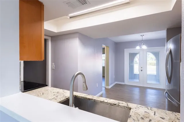 a kitchen with stainless steel appliances kitchen island a refrigerator sink and cabinets