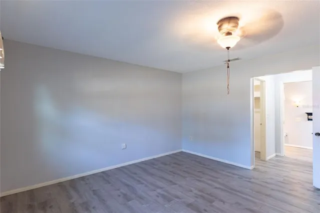 a view of a room with wooden floor and a ceiling fan