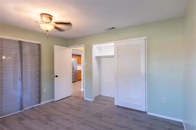 a view of a livingroom with wooden floor and a ceiling fan