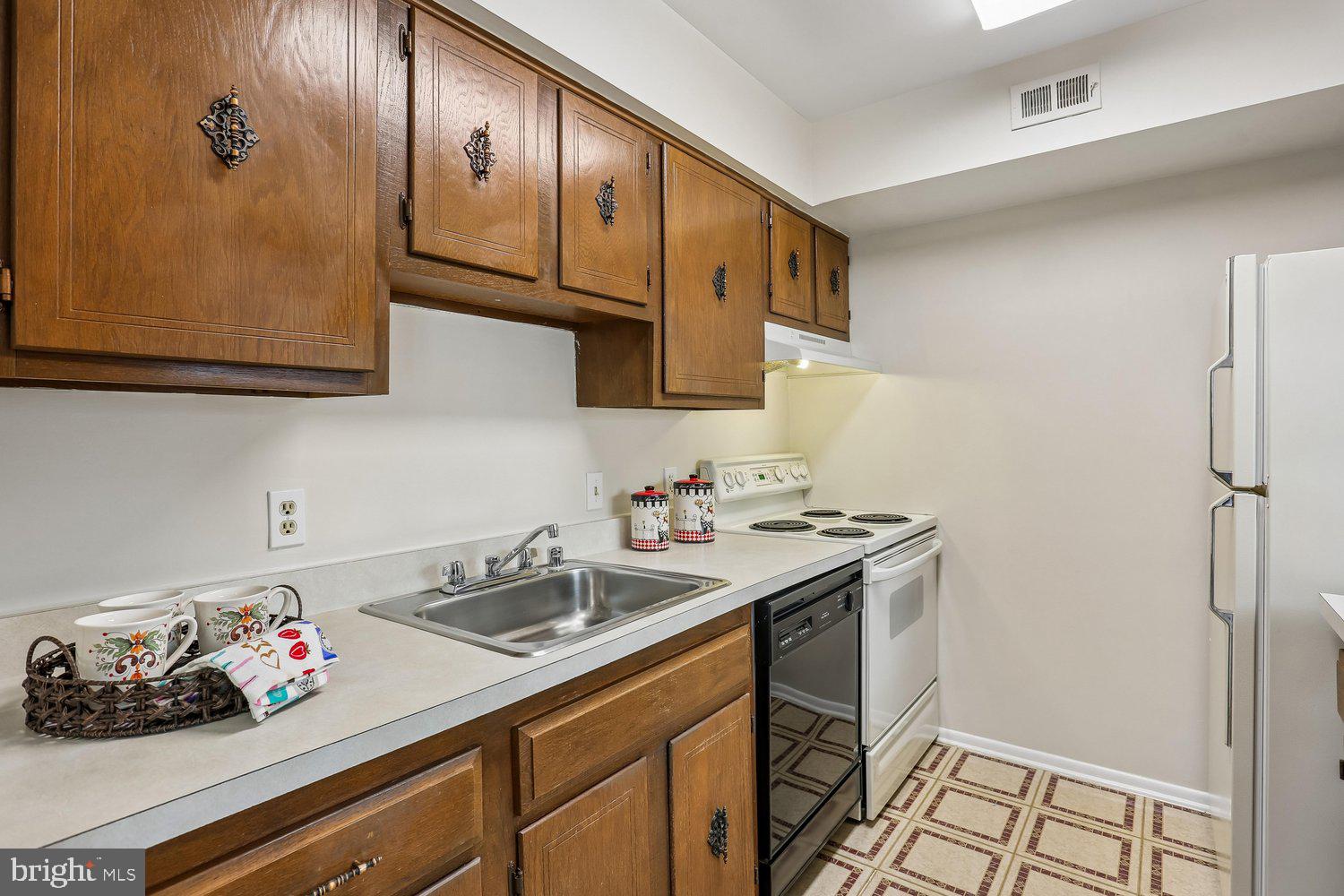 15020 Eardley Court, Unit 281G Silver Spring, MD 20906 - Photo 12 of 20 a kitchen with a sink cabinets and a stove top oven